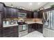 A well-equipped kitchen with stainless steel appliances and dark wood cabinetry at 1309 Piney Woods Path, The Villages, FL 32163
