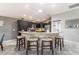 An open-concept kitchen features a stone-accented island and stainless steel appliances at 1309 Piney Woods Path, The Villages, FL 32163