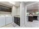 Functional laundry room with washer, dryer, dark cabinets, sink, and view of the kitchen at 1309 Piney Woods Path, The Villages, FL 32163