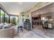 Inviting sunroom with brick accent walls, floor-to-ceiling windows, tile flooring, and view of the kitchen at 1309 Piney Woods Path, The Villages, FL 32163