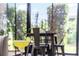Bright sunroom view with table, chairs and greenery shown behind a refreshing drink at 1309 Piney Woods Path, The Villages, FL 32163