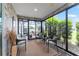 Relaxing sunroom with stone accent walls, tile flooring, outdoor view and wicker furniture at 1309 Piney Woods Path, The Villages, FL 32163