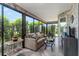 Bright sunroom featuring stone accent walls, tile flooring, large windows, and comfortable seating at 1309 Piney Woods Path, The Villages, FL 32163