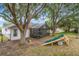 A beautiful backyard with mature trees and a screened patio, also includes a play area at 13332 Via Roma Cir, Clermont, FL 34711
