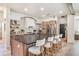 Spacious kitchen featuring a large island with seating, stainless steel appliances, and custom backsplash at 13332 Via Roma Cir, Clermont, FL 34711