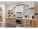 Tasteful kitchen features stainless steel oven, floating shelves, decorative backsplash, and wood cabinetry at 13332 Via Roma Cir, Clermont, FL 34711