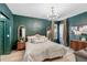 Green main bedroom featuring a decorative chandelier, wood floors, matching dressers and neutral bedding at 13332 Via Roma Cir, Clermont, FL 34711