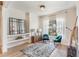 Sitting room featuring decorative mirror, comfortable teal chairs, and large bright window at 13332 Via Roma Cir, Clermont, FL 34711