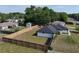 A sprawling backyard with a wooden fence surrounds a home with a dark roof and an expanse of lush green grass at 14350 Se 36Th Ave, Summerfield, FL 34491