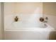 Clean bathroom featuring a large soaking tub and white-tile surround at 14350 Se 36Th Ave, Summerfield, FL 34491
