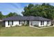Charming single-story home featuring a well-manicured lawn and freshly painted exterior at 14350 Se 36Th Ave, Summerfield, FL 34491