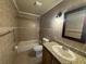 Bathroom featuring a granite counter, modern light fixture and tiled walls at 14466 Se 45Th Ct, Summerfield, FL 34491