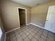 Bedroom featuring tile floors and a closet with shelving for efficient storage solutions at 14466 Se 45Th Ct, Summerfield, FL 34491