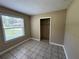 Bedroom with closet and window for natural light, enhanced by neutral walls and tile flooring at 14466 Se 45Th Ct, Summerfield, FL 34491