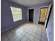 Bedroom featuring tile floors, an open closet and a view into the hallway at 14466 Se 45Th Ct, Summerfield, FL 34491