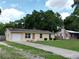 The attractive single Gathering home sits on a green lawn with a concrete driveway and mature trees at 14466 Se 45Th Ct, Summerfield, FL 34491