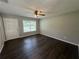 Bright and airy living room with stylish dark LVP flooring, ceiling fan, and a bright white door at 14466 Se 45Th Ct, Summerfield, FL 34491
