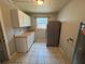 Utility room with white cabinets, laminate counters, neutral walls, and a tiled floor at 14466 Se 45Th Ct, Summerfield, FL 34491