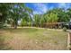 Beautiful backyard featuring mature trees, a wooden pergola, and a fire pit at 14490 Se 96Th Ter, Summerfield, FL 34491