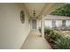 A welcoming entrance with a security screen door, framed by decorative wall hangings and lush foliage at 14490 Se 96Th Ter, Summerfield, FL 34491