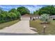 Well-kept single-story home with a large driveway, mailbox, manicured lawn and lush landscaping at 14490 Se 96Th Ter, Summerfield, FL 34491