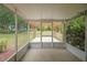 Spacious screened-in porch with a view of the wooden pergola and landscaped backyard at 14490 Se 96Th Ter, Summerfield, FL 34491