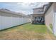 Spacious backyard with a covered patio, white fence, and green lawn, perfect for outdoor dining and recreation at 14832 Royal Poinciana Dr, Orlando, FL 32828