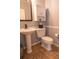 Cozy bathroom featuring a classic pedestal sink and a matching toilet, complemented by tiled floors at 14832 Royal Poinciana Dr, Orlando, FL 32828