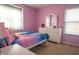 A bright bedroom featuring lilac walls, a large window, and coordinated furniture at 14832 Royal Poinciana Dr, Orlando, FL 32828