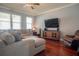 Living room with large windows, hardwood floors, comfortable seating, and a TV at 14832 Royal Poinciana Dr, Orlando, FL 32828