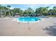 Large community pool surrounded by lounge chairs and lush landscaping, offering a perfect place for relaxation and recreation at 14832 Royal Poinciana Dr, Orlando, FL 32828