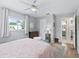 Light-filled bedroom with wood floors, complemented by a ceiling fan and en-suite access to the bathroom at 17819 Se 105Th Ct, Summerfield, FL 34491