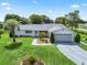 Charming single-story home with a well-manicured lawn, mature landscaping, and a two-car garage at 17819 Se 105Th Ct, Summerfield, FL 34491