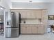 Spacious kitchen features stainless steel refrigerator, light wood cabinets, and ample countertop space at 17819 Se 105Th Ct, Summerfield, FL 34491