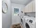Laundry room with appliances, storage cabinets, and door to the outside at 17819 Se 105Th Ct, Summerfield, FL 34491
