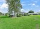 Expansive green lawn, beautifully landscaped with lush plantings, leading to a screened-in pool area at 17819 Se 105Th Ct, Summerfield, FL 34491