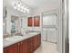 Bathroom with double sinks, cabinets, and a view into the laundry area at 17916 Se 87Th Melrose Ct, The Villages, FL 32162