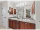 Bright bathroom featuring a double vanity, granite countertops, and a large mirror at 17916 Se 87Th Melrose Ct, The Villages, FL 32162