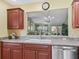 Open kitchen view showcases stainless steel dishwasher and sink under a window to living area at 17916 Se 87Th Melrose Ct, The Villages, FL 32162