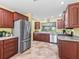 Spacious kitchen featuring stainless steel appliances, tile floors, and stylish wood cabinetry at 17916 Se 87Th Melrose Ct, The Villages, FL 32162