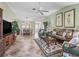 Open-concept living area showcasing tile floors, wicker furnishings, and connection to the kitchen and patio at 17916 Se 87Th Melrose Ct, The Villages, FL 32162