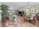 Bright, open living room featuring tile floors, wicker furniture, and sliding door access to the outdoors at 17916 Se 87Th Melrose Ct, The Villages, FL 32162