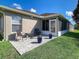 Charming backyard patio featuring comfortable seating, potted plants, and a well-kept lawn at 1914 Armondo Dr, The Villages, FL 32159