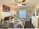Inviting bedroom with a large window, stylish bedding, and a dresser that adds to the room's charm at 1914 Armondo Dr, The Villages, FL 32159