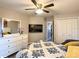 Comfortable bedroom featuring a ceiling fan, a mounted TV, and a large closet for ample storage at 1914 Armondo Dr, The Villages, FL 32159