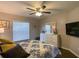 Bright bedroom with a ceiling fan, a dresser, and large windows for natural light and style at 1914 Armondo Dr, The Villages, FL 32159