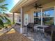 Covered front porch with seating area, ceiling fan, and views of landscaped yard at 1914 Armondo Dr, The Villages, FL 32159