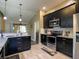 Modern kitchen with stainless steel appliances, dark wood cabinets, and a breakfast bar at 1914 Armondo Dr, The Villages, FL 32159