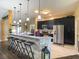 Modern kitchen with an extended stone breakfast bar, stainless steel appliances, and dark cabinetry at 1914 Armondo Dr, The Villages, FL 32159