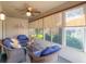 Cozy lanai with comfortable seating, ceiling fan, and views of the lush backyard at 1914 Armondo Dr, The Villages, FL 32159